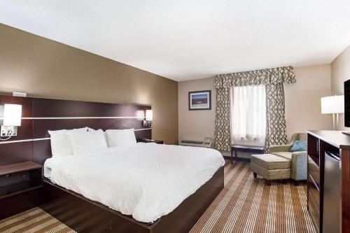 a hotel room with a large bed and a chair at Pocono Inn & Banquet - Stroudsburg in Delaware Water Gap