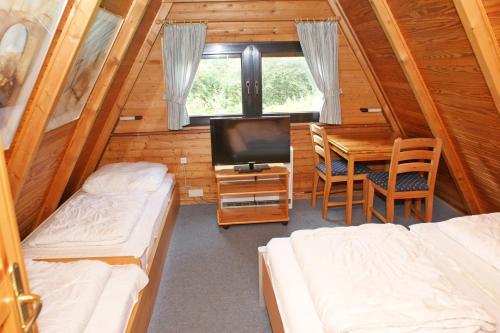 Habitación con 2 camas, mesa y TV. en Zeltdachhaus _ 2 x TV _ ruhige Lag en Damp