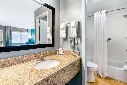 Un baño con lavabo, inodoro y espejo. en Comfort Inn Sun City Center - Ruskin - Tampa South, en Sun City Center