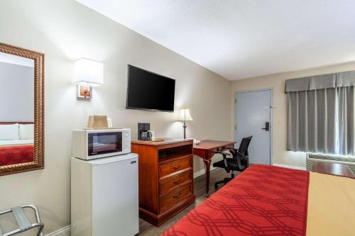 a hotel room with a bed and a desk with a television at Econo Lodge Lincoln in Lincoln