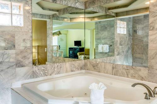 un bagno con vasca e un grande specchio di Econo Lodge Beach and Boardwalk ad Atlantic City