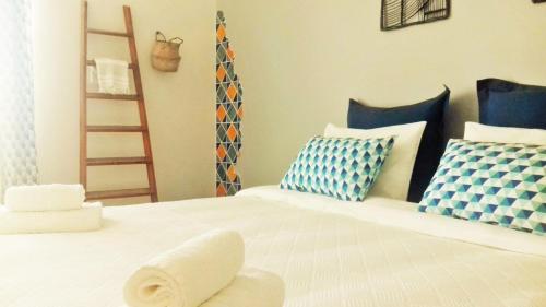 a bedroom with a bed with blue and white pillows at Alojamentos Vista Mar-Luisa Todi in Setúbal