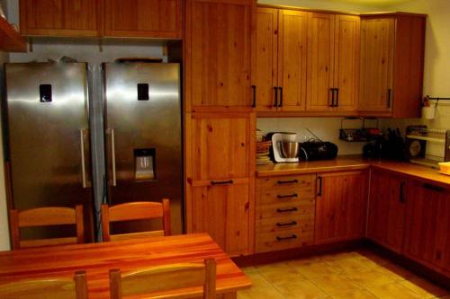 a kitchen with wooden cabinets and stainless steel appliances at Dom pod Dziką Gruszą in Piecki