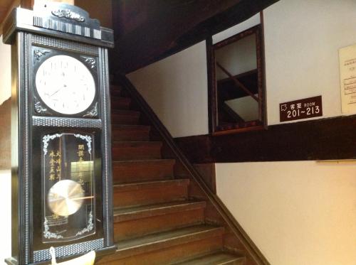 a clock sitting on the side of a staircase at Chikurinin Gunpoen in Yoshino