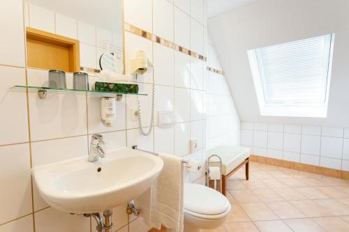 a bathroom with a sink and a toilet at Altora Eisenbahn Themenhotel in Wernigerode