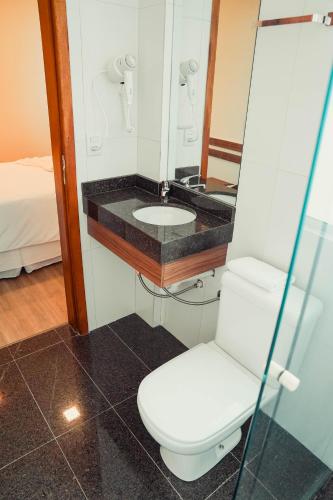 a bathroom with a toilet and a sink at Hotel Imperial de Quatro Barras in Quatro Barras
