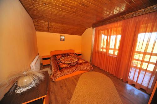 a bedroom with a bed and a large window at Cabana Sebes Bera in Făgăraş