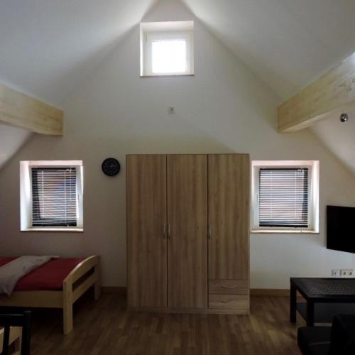 una camera da letto con un armadio in legno e due finestre di Boardinghouse Hauptstrasse23a a Bühl