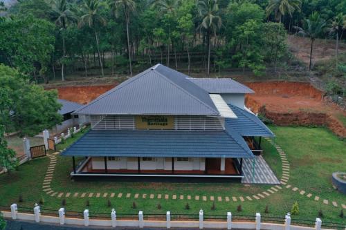 a house with a blue roof and a yard at Thenmala Heritage in Kollam