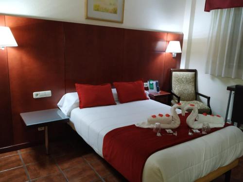 a hotel room with two beds and a lamp at Pensión El Otero in Guadalajara