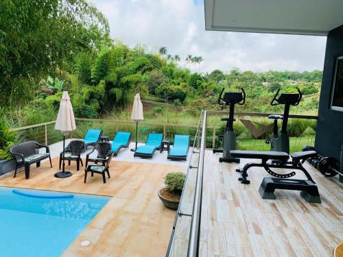 a gym with chairs and a swimming pool at CASA LUZ Hospedaje, Pereira , Cerritos in Pereira
