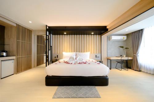a bedroom with a large white bed with flowers on it at Loft Bangkok Hotel in Bangkok