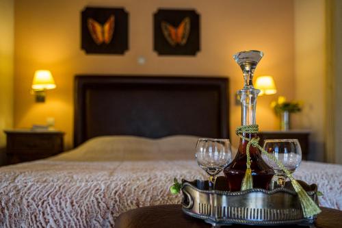 a tray with wine glasses on a table next to a bed at Naiades Guesthouse in Klávsion