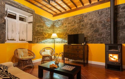 a living room with yellow walls and a fireplace at Casa da Fazenda (Mountain View) in Conceição