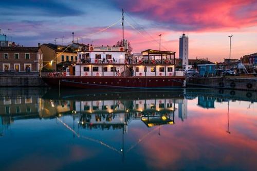 a boat is docked in the water at sunset at Castello Montegiove in Fano