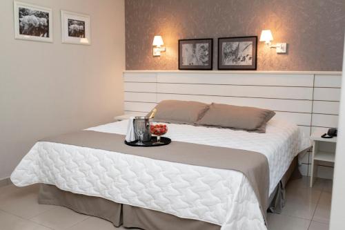 a bedroom with a white bed with a tray on it at Hotel San Paolo in Pederneiras
