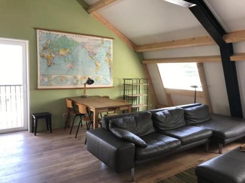 a living room with a leather couch and a table at ROYAAL APPARTEMENT CENTRUM MIDDELBURG in Middelburg