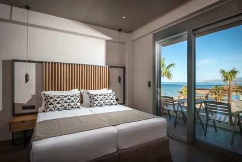 a bedroom with a bed and a view of the ocean at Riviera Boutique Hotel in Stalida