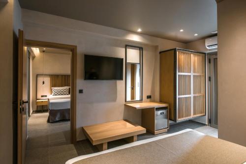 a room with a television and a room with a bed at Riviera Boutique Hotel in Stalida