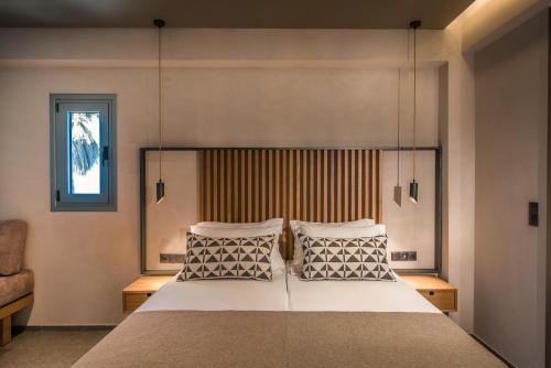 a bedroom with a large bed with two pillows at Riviera Boutique Hotel in Stalida