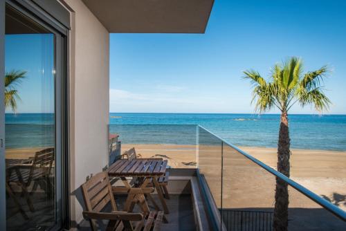 a balcony with a table and a view of the beach at Riviera Boutique Hotel in Stalida