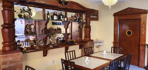 a dining room with two tables and a shelf of wine bottles at El Jardín Del Edén in Tequisquiapan
