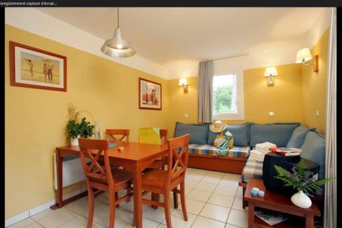 un salon avec une table et un canapé dans l'établissement Appartement près lac et océan, à Carcans