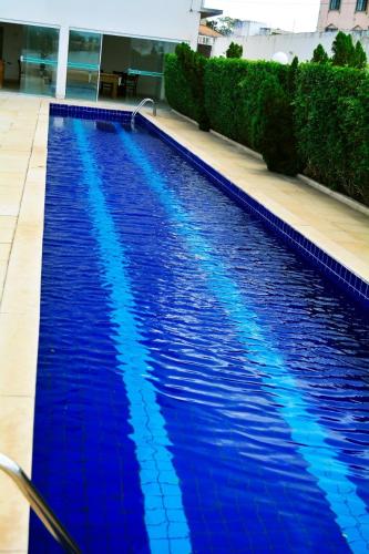 a large blue swimming pool in a building at Hotel Áster in Alagoinhas