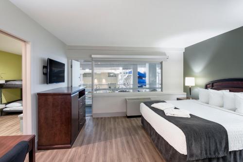 a hotel room with a bed and a television at Viscount Gort Hotel, Banquet & Conference Centre in Winnipeg