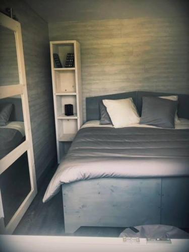 - une petite chambre avec un lit et une étagère dans l'établissement Cottage tout confort au milieu des chevaux, à Saint-Fargeau