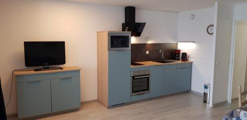 - une cuisine avec une télévision au-dessus d'un comptoir dans l'établissement Ti Korelo Sables Blancs, à Douarnenez