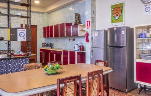 a kitchen with a wooden table and a refrigerator at Flying Dog Hostel Iquitos in Iquitos