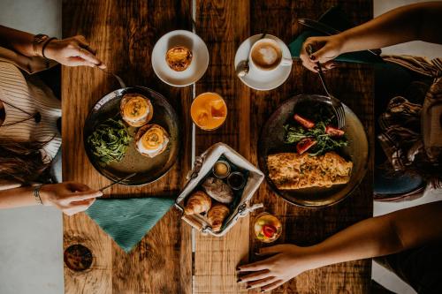 un grupo de personas sentadas alrededor de una mesa con comida en Selina Secret Garden Lisbon by IKIGAI Global Hospitality, en Lisboa