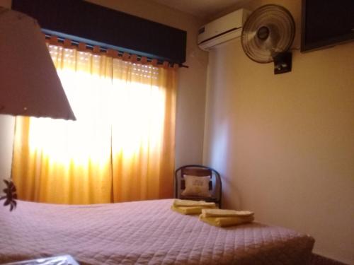 1 dormitorio con 1 cama y ventana con ventilador en Vergniaud 70 en Colón