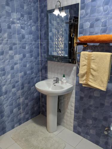 ein Bad mit einem Waschbecken und einer Glasdusche in der Unterkunft Full Appart Hôtel in Kenitra