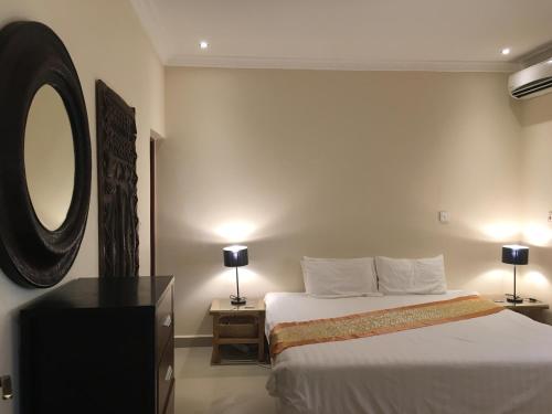 a hotel room with a bed and a mirror at Kololi Beach Resort in Kololi