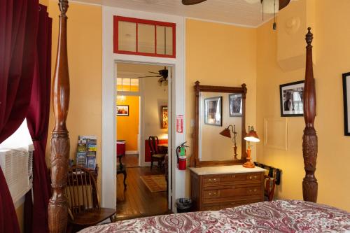 a bedroom with a bed and a mirror at The Blue60 Marigny Inn in New Orleans