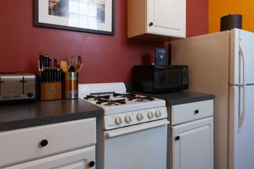 a kitchen with a white stove top oven next to a refrigerator at The Blue60 Marigny Inn in New Orleans