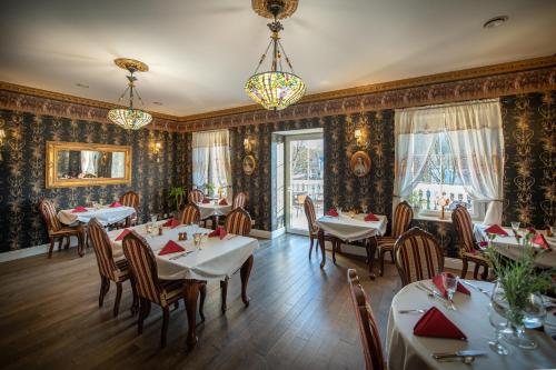 - un restaurant avec des tables et des chaises dans une salle ornée de papier peint dans l'établissement Rezydencja Grawert Boutique & Spa, à Lądek-Zdrój