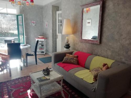 a living room with a couch with a colorful blanket at Appartement St Martin du Canigou in Casteil