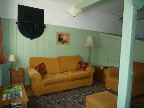 a living room with a couch and a table at Brackenborough Hall Coach House - Saddle Room in Louth