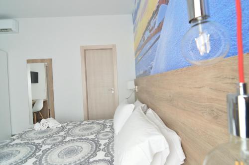 Schlafzimmer mit einem Bett mit einem Kopfteil aus Holz in der Unterkunft Casa Corvaja in Taormina