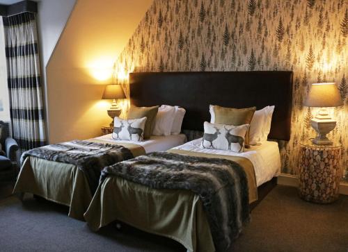 um quarto de hotel com duas camas e duas lâmpadas em No12 Hotel em North Berwick
