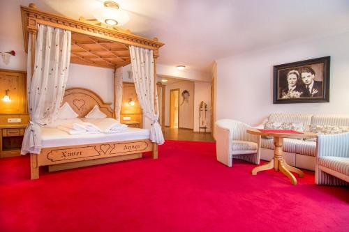 1 dormitorio con cama con dosel y alfombra roja en Hotel Ischgl, en Ischgl