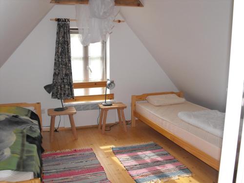 a small room with a bed and a window at Rukkilille Holiday Home in Pärsama
