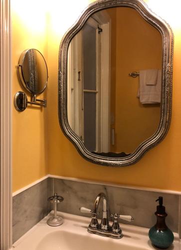 a bathroom with a sink with a large mirror at The Blue60 Marigny Inn in New Orleans