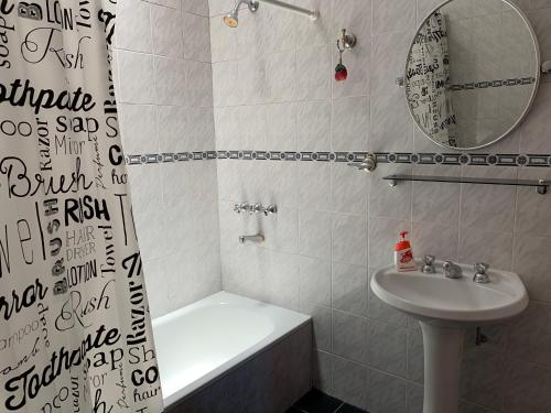 ein Badezimmer mit einem Waschbecken, einer Badewanne, einem WC und einem Spiegel in der Unterkunft Like home 2 in Salta