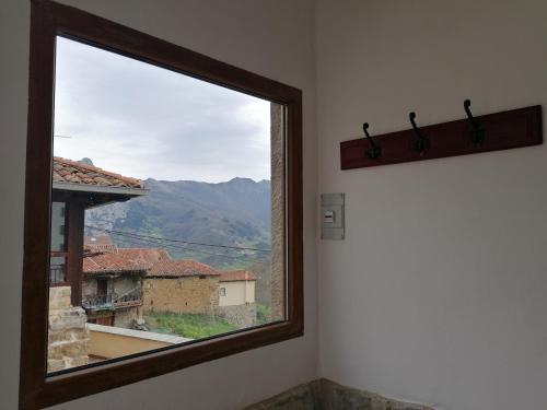 a window in a room with a view of a mountain at Casa Rural el Enebral en Potes Picos de Euopa in Colio