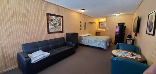 une chambre d'hôtel avec un canapé et un lit dans l'établissement Highport INN, à Pottsboro