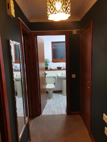 a bathroom with a toilet and a sink and a chandelier at 2 Raasay Court in Portree